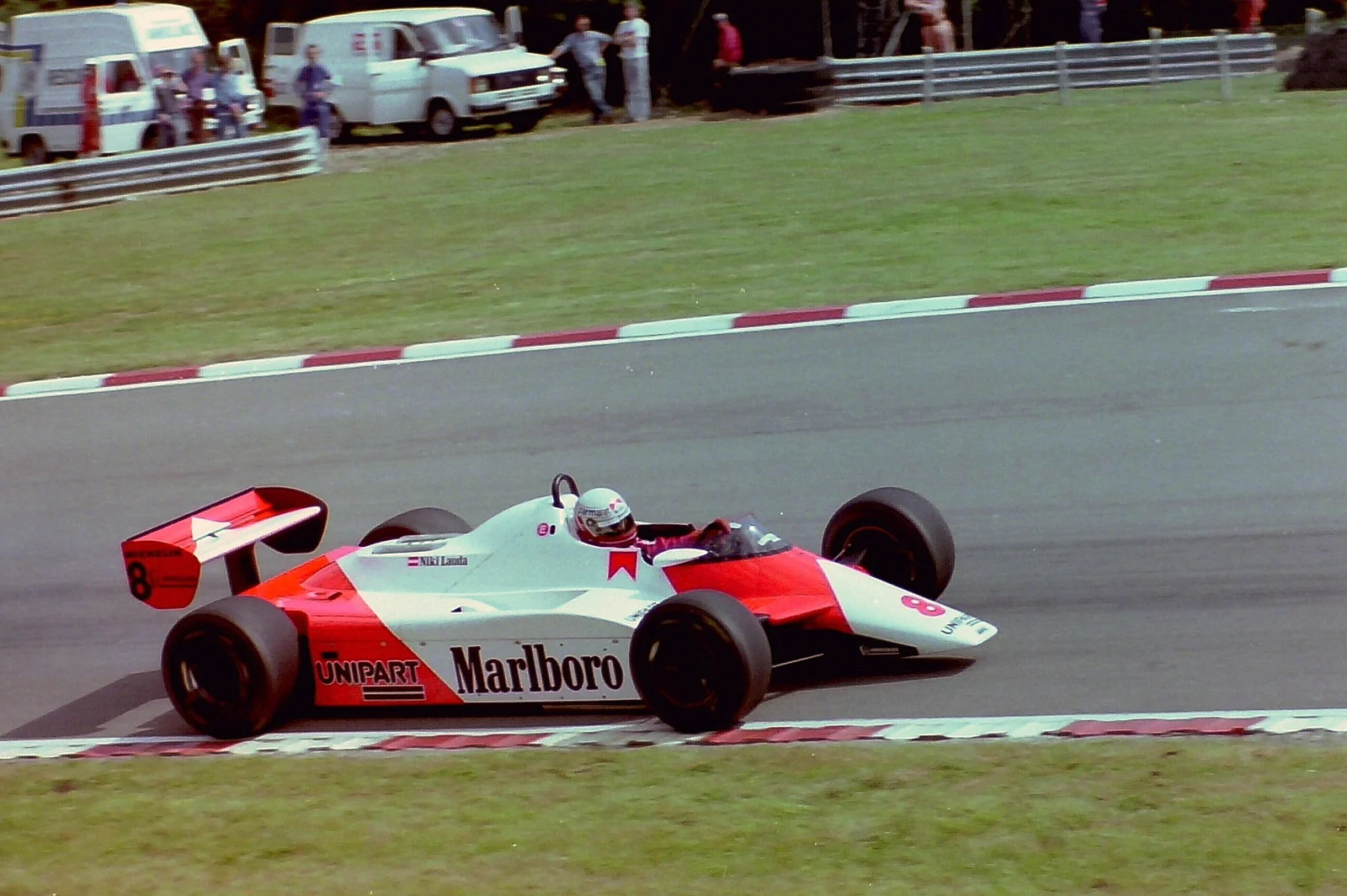 An archival red and white single-seater in motion.