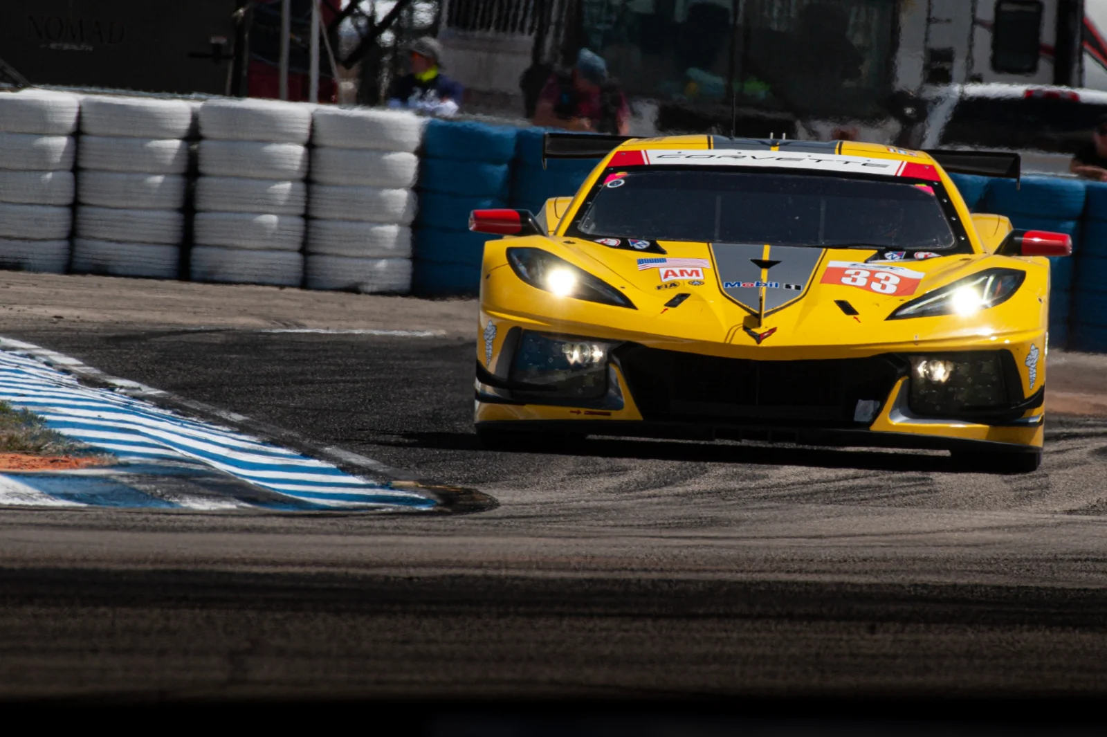 A yellow GT race car approaching a bend.