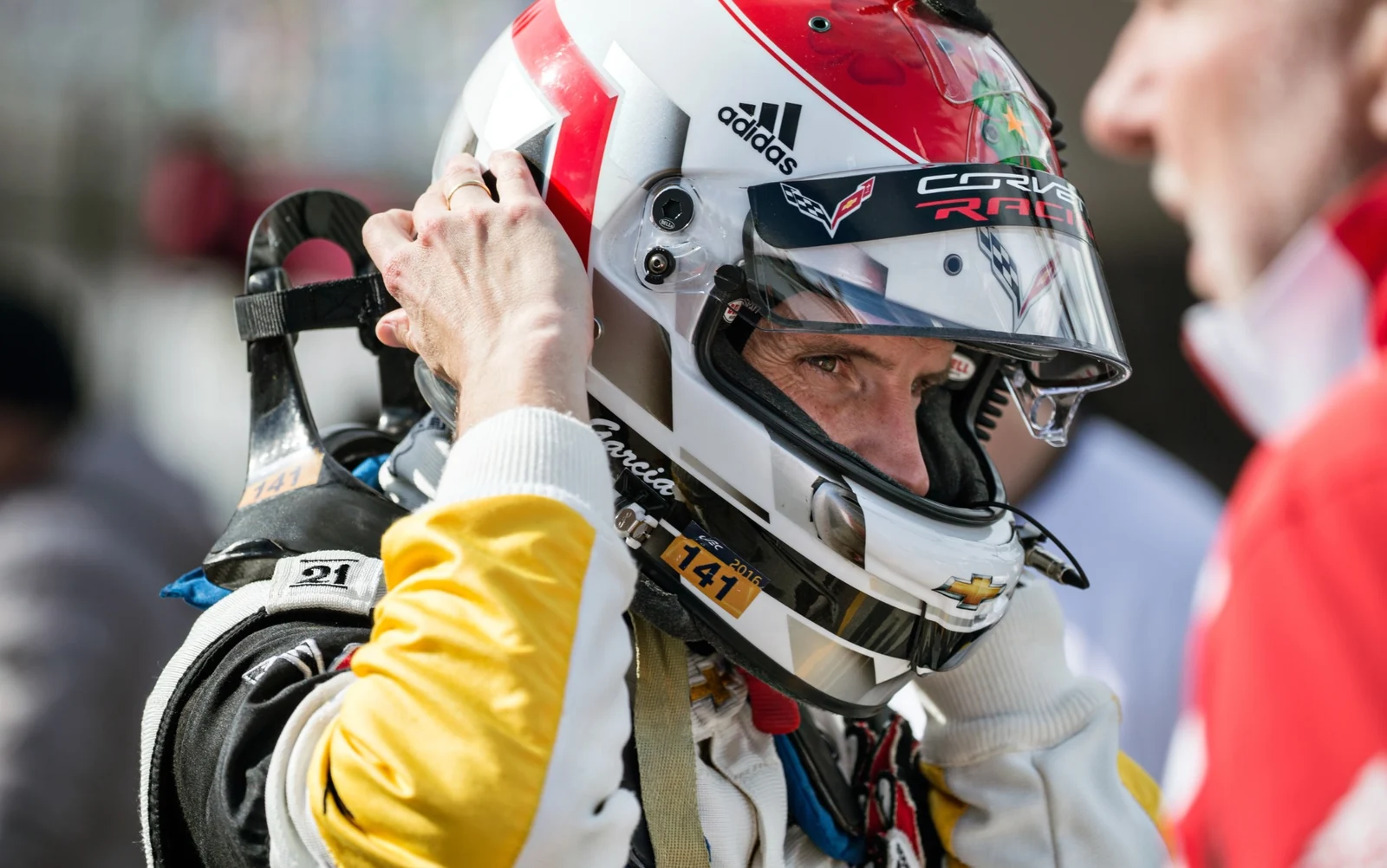 A racing driver preparing equipment before a session.
