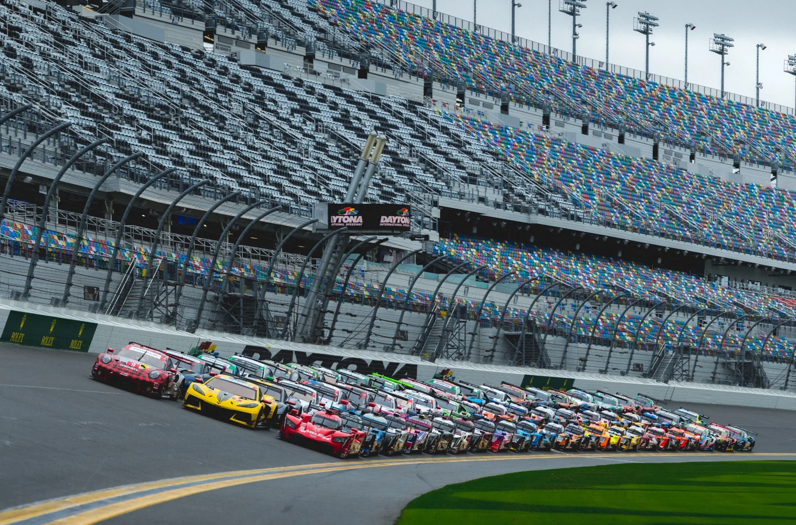 GT and prototype race cars assembled on a banked circuit.