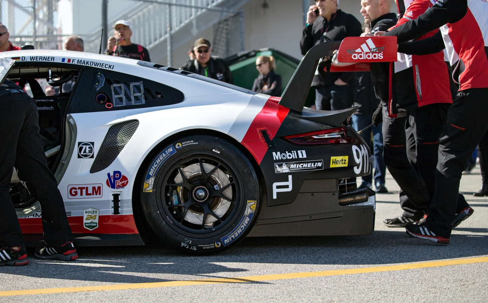 A race car and crew in the paddock.